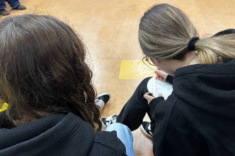 Zwei Schülerinnen die in der Gruppenarbeit der Lions-Quest-Stunde auf einen Zettel eine überlegte "Ich"-Botschaft verfassen